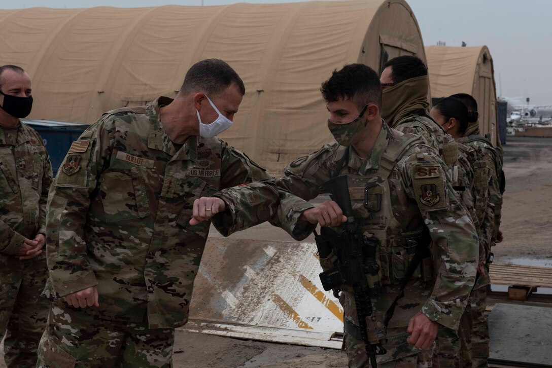 Lt. Gen. Greg Guillot, 9th Air Force (Air Forces Central) commander, coins Senior Airman Abdallah Shawabkeh, 387th Expeditionary Security Forces Squadron defender, at Cargo City, Kuwait, Dec. 4, 2020. During his visit, Guillot coined Airmen recognized by their leadership for performing above and beyond in their duties. (U.S. Air Force photo by Staff Sgt. Kenneth Boyton)