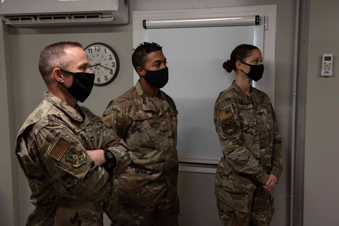 Chief Master Sgt. John Storms, 9th Air Force (Air Forces Central) command chief, left, Tech. Sgt. Stephan DaCosta, 387th Expeditionary Civil Engineer Flight NCO in charge, center, and Tech. Sgt. Victoria Haley, 387th Expeditionary Support Squadron logistics readiness NCOIC, right, listen to a brief at Cargo City, Kuwait, Dec. 4, 2020. During the brief, Storms and Lt. Gen. Greg Guillot, 9th AF (AFCENT) commander, gained firsthand knowledge on how the base operates and its plans for the future. (U.S. Air Force photo by Staff Sgt. Kenneth Boyton)