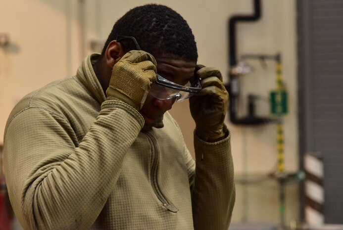 An Airman donning safety goggles.