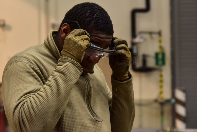 An Airman donning safety goggles.