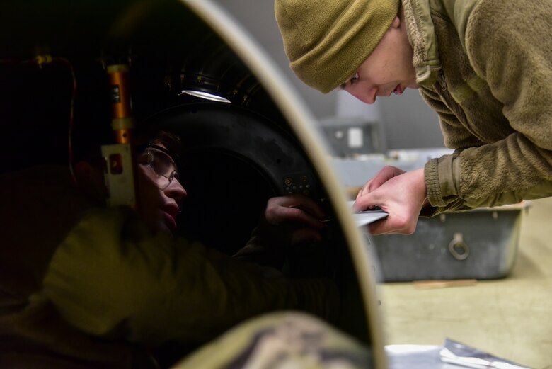 Airmen tightening bolts.