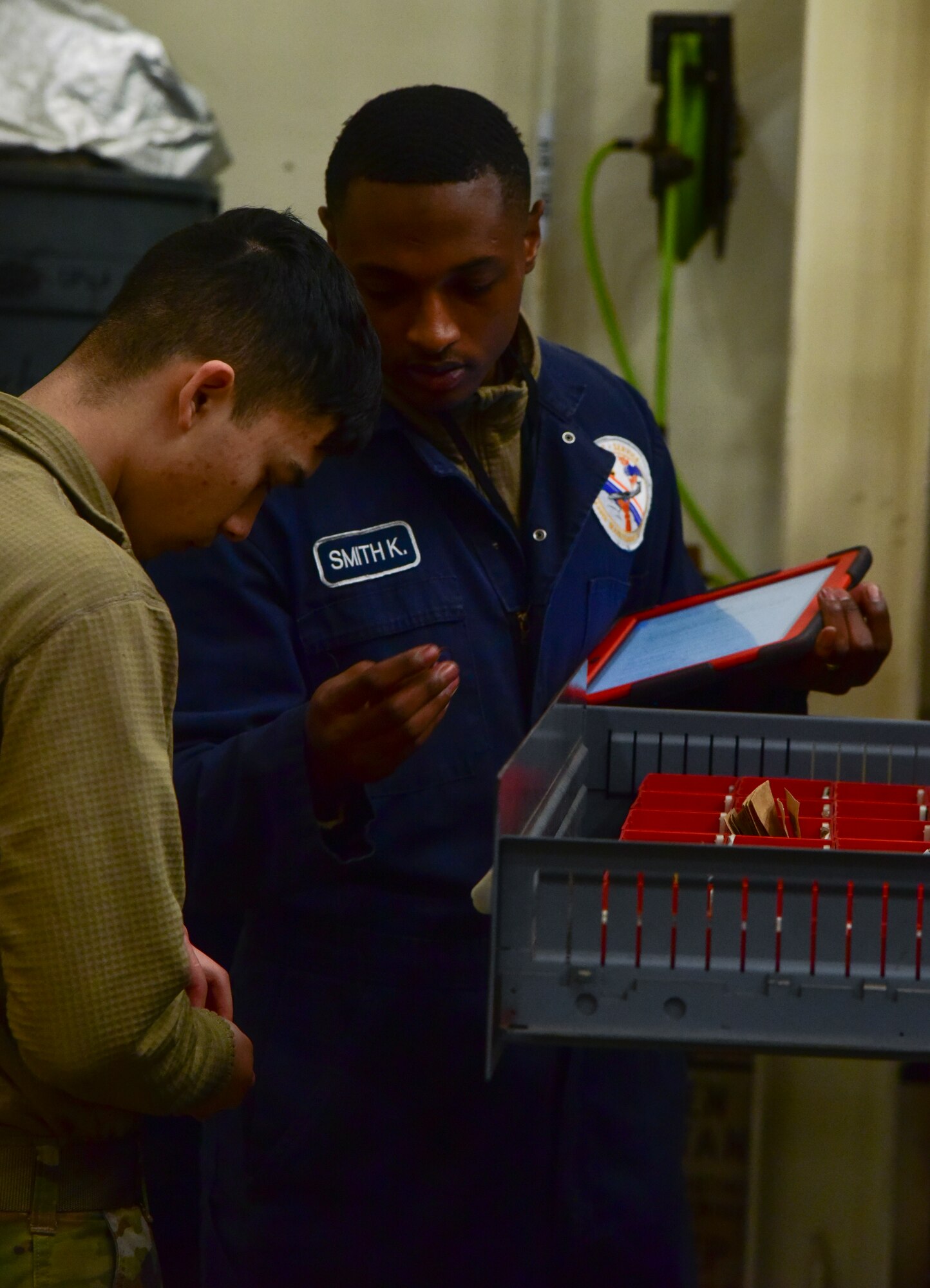 Airmen examining various maintenance tools.