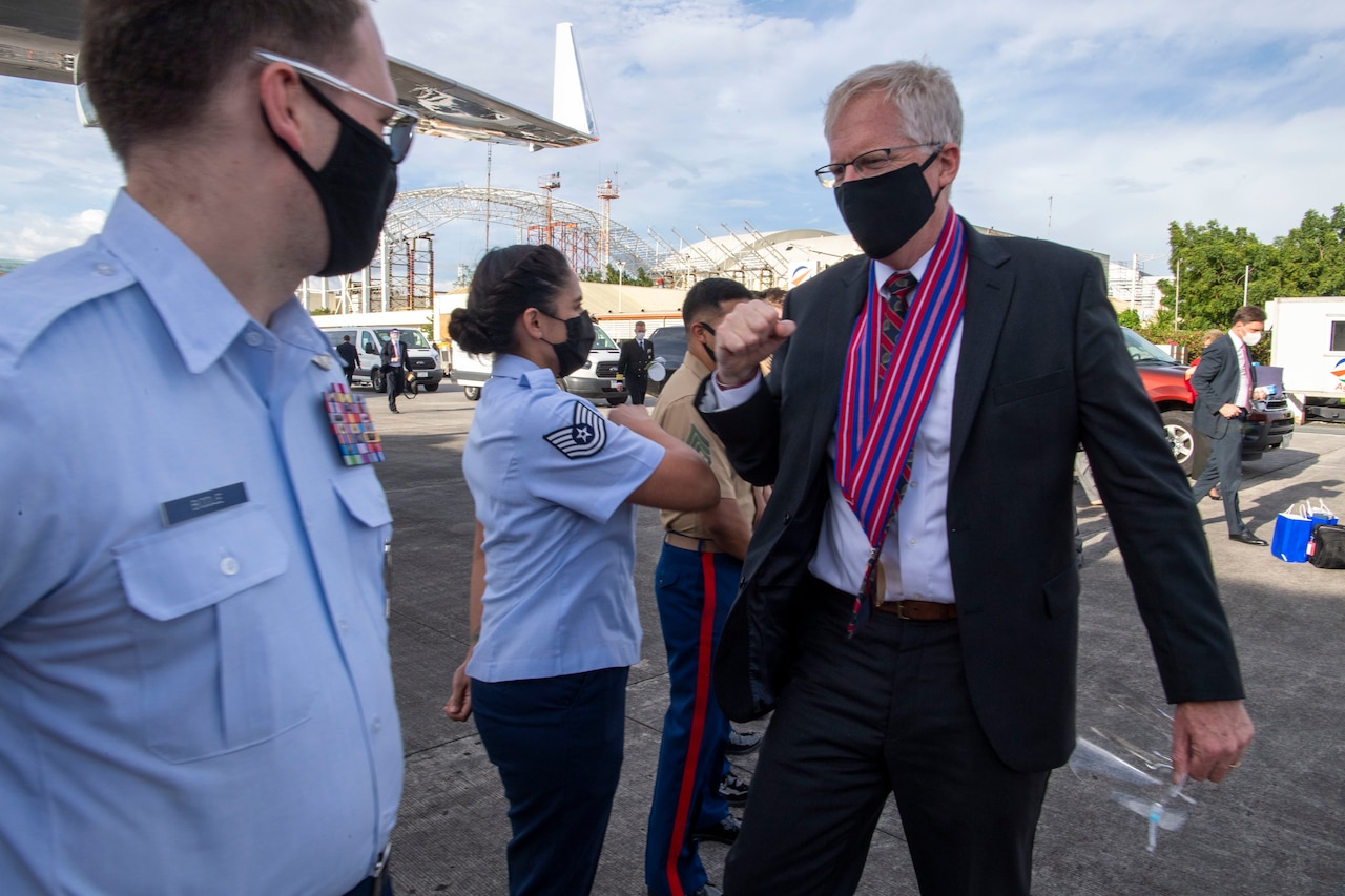 A man meets with service members in the Philippines.