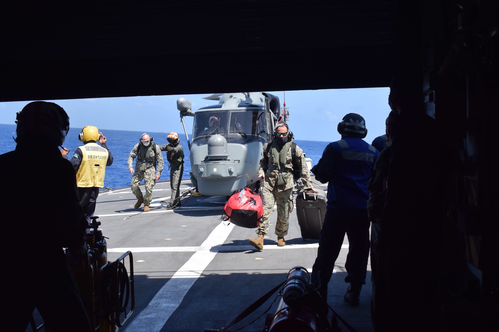 Military personnel board a ship.