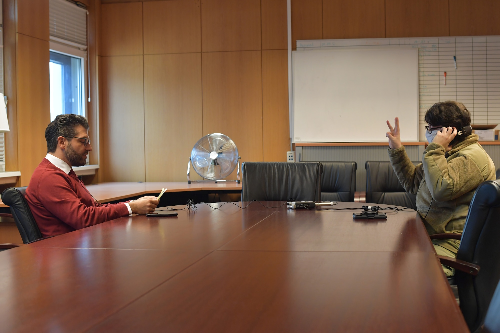 A man sits across the table from an Airman.