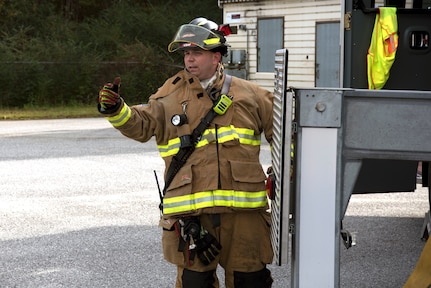 Christopher Swift, a driver operator for the 628th Civil Engineer Squadron, signals to start the training exercise, at Joint Base Charleston, S.C., Dec. 3, 2020. Swift and his team members at the 628th CES Fire Department support the mission by saving lives and protecting the people of Joint Base Charleston.