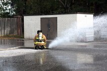 Chaz Cools, a firefighter for the 628th Civil Engineer Squadron, demonstrates how to stop a faulty hose from losing control by diving and applying pressure on the hose, at Joint Base Charleston, S.C., Dec. 3, 2020. Swift and his team members at the 628th CES Fire Department support the mission by saving lives and protecting the people of Joint Base Charleston.