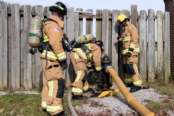 Civilians and Airmen from the 628th Civil Engineer Squadron, dismount a faulty hose from a fire hydrant during a training exercise, at Joint Base Charleston, S.C., Dec. 3, 2020. Swift and his team members at the 628th CES Fire Department support the mission by saving lives and protecting the people of Joint Base Charleston.