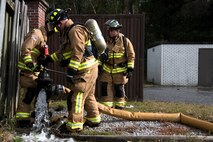 Civilians and Airmen from the 628th Civil Engineer Squadron, dismount a faulty hose from a fire hydrant during a training exercise, at Joint Base Charleston, S.C., Dec. 3, 2020. Swift and his team members at the 628th CES Fire Department support the mission by saving lives and protecting the people of Joint Base Charleston.