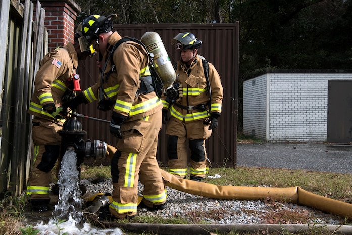 Civilians and Airmen from the 628th Civil Engineer Squadron, dismount a faulty hose from a fire hydrant during a training exercise, at Joint Base Charleston, S.C., Dec. 3, 2020. Swift and his team members at the 628th CES Fire Department support the mission by saving lives and protecting the people of Joint Base Charleston.