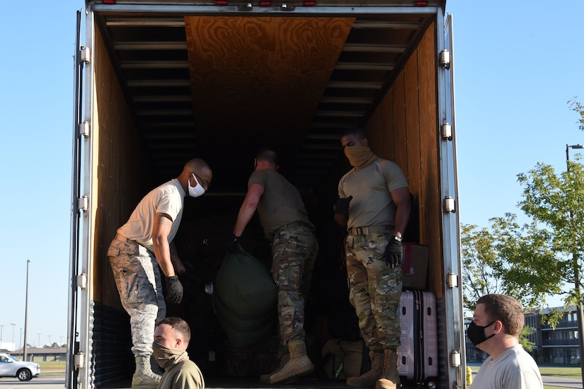 Service members load a truck.