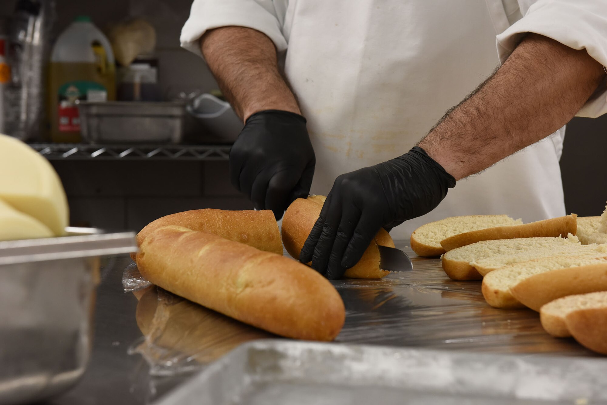 Don Paulos, Elkhorn Dining Facility chef, slices bread in preparation for the lunch hour, Dec. 1, 2020, at Malmstrom Air Force Base, Mont. Chefs and Airmen work together in the kitchen to prepare the most quality and healthy options available for mission success. (U.S. Air Force photo by Airman Elijah Van Zandt)