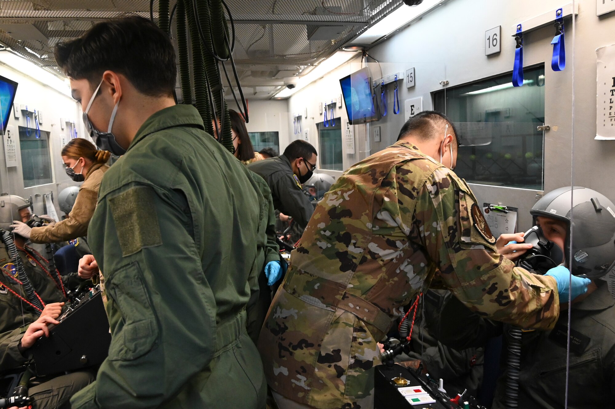 U.S. Air Force aerospace physiology technicians with the 14th Operations Support Squadron help prepare pilots from the 37th Flying Training Squadron for hypobaric chamber training Dec.7, 2020, on Columbus Air Force Base, Miss. During hypobaric chamber training, pilots go through a series of test to simulate the effects of high altitude, such as low oxygen and low ambient air pressure. (U.S. Air Force photo by Airman 1st Class Jessica Williams)