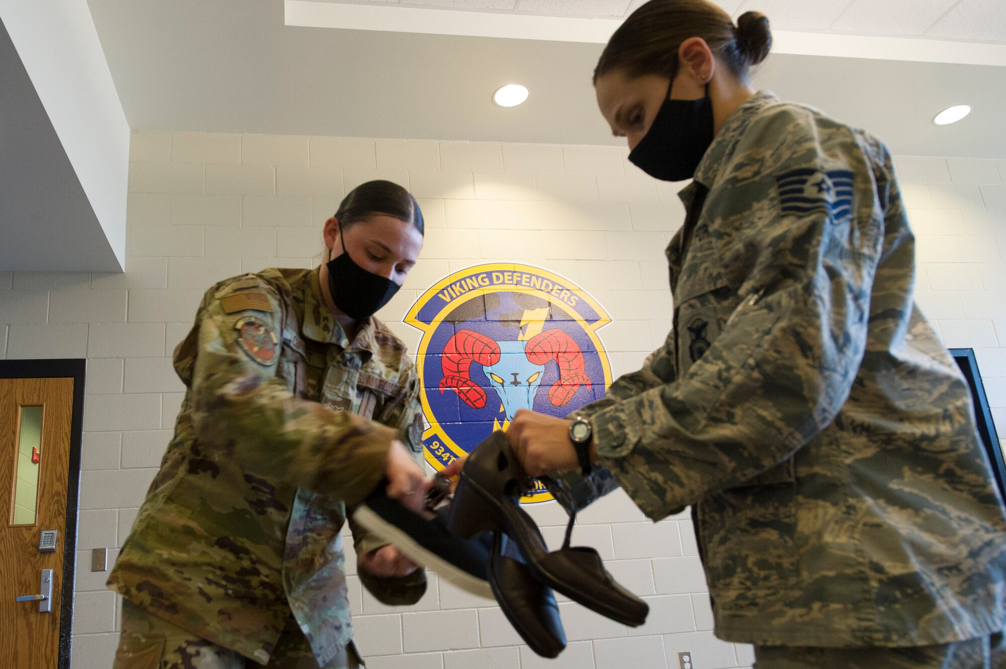 Airmen Sarah Corbett, 934th Security Forces fire team member, and Tech Sgt. Kathryn Cross, 934th Airlift Wing staff additional duty first sergeant, sort through donated shoes from a donation drive during November unit training assembly at Minneapolis-St. Paul Air Reserve Station, November 18, 2020. (U.S. Air Force photo by Chris Farley)