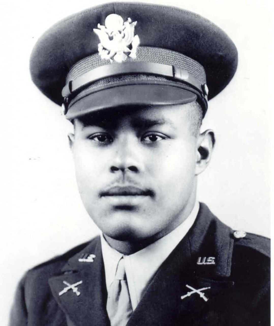 A man in an officer’s uniform looks at the camera.