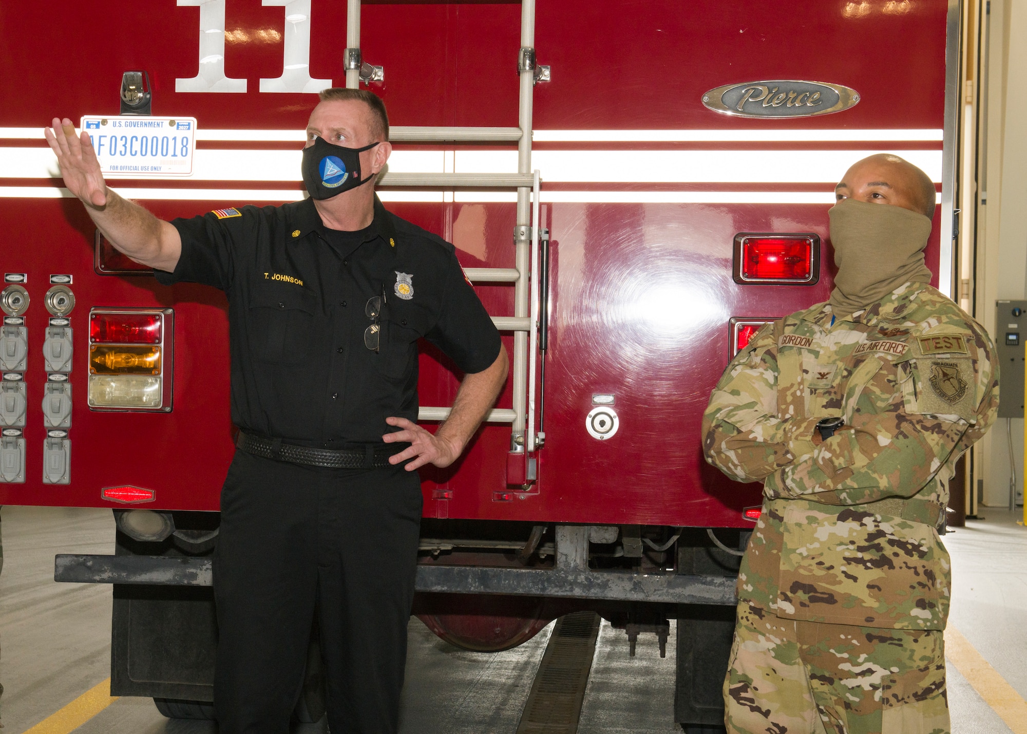 Chief Timothy Johnson, Edwards AFB FES Fire Chief, provides fine details of a mural at the new Airfield Fire Station at Edwards Air Force Base, California, while Col. Randel Gordon, 412th Test Wing Vice Commander, takes a closer look, Dec. 8. The mural was painted in 1992 by a former firefighter and was moved to the new facility to showcase the firefighter's history at Edwards. (Air Force photo by Giancarlo Casem)