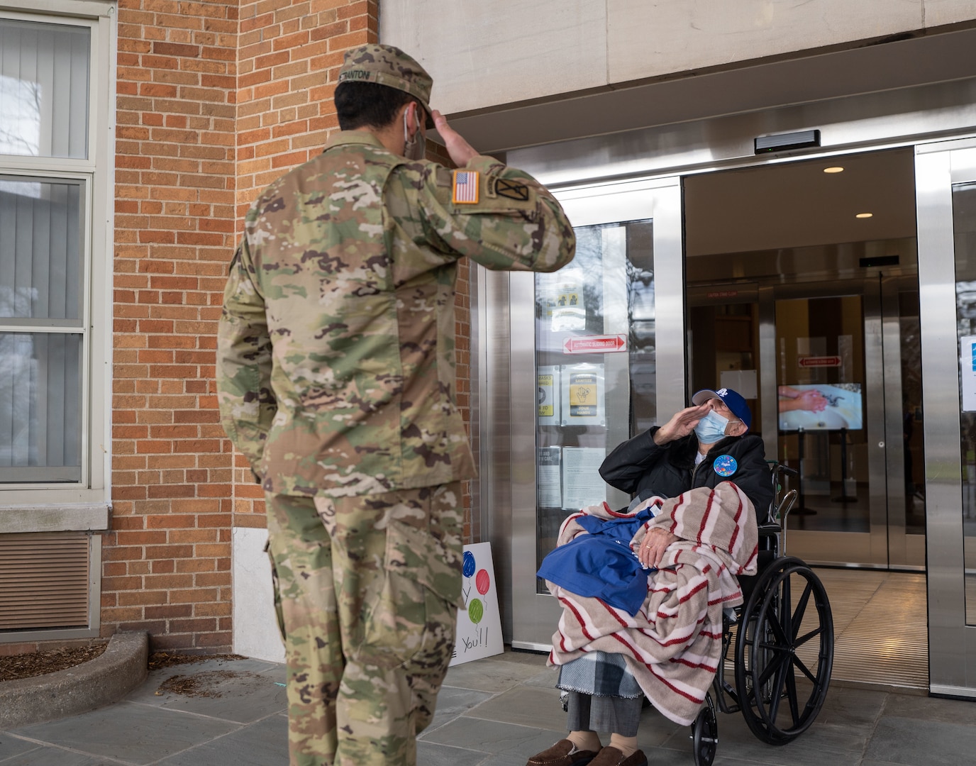 U.S. Army Staff Sgt. Jonathan Pietrantoni, assigned to the 53rd Troop Command, New York Army National Guard, salutes World War II veteran Pfc. Joseph Casaburi on his 99th birthday after he survived a three-month long battle with COVID-19 at the nursing home Angus on Hudson, Hastings-on-Hudson, N.Y., on Dec. 8, 2020.