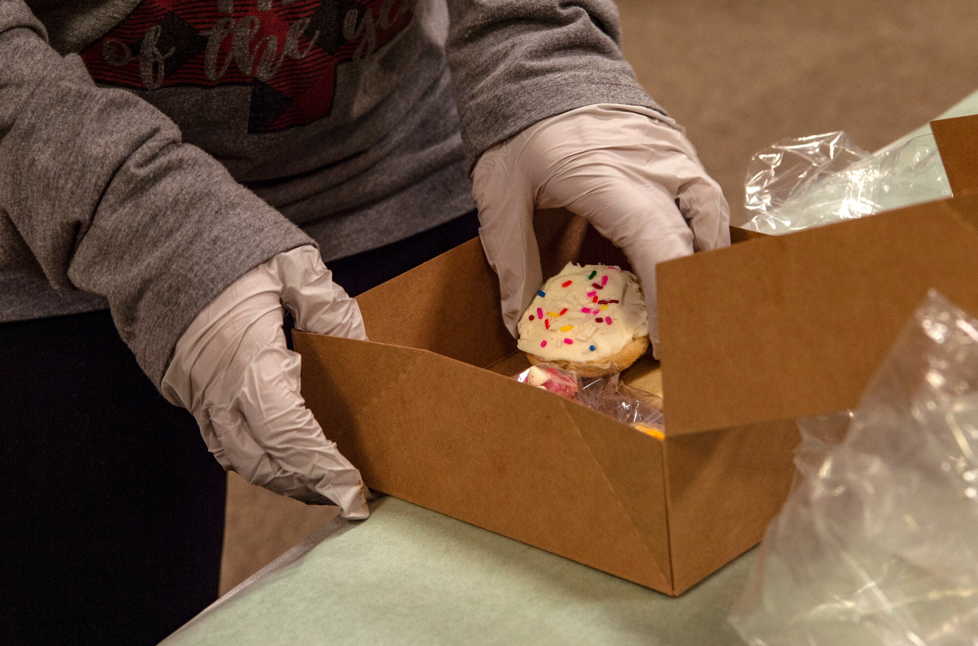 Brooke Bezerra, Operation Cookie Drop volunteer and spouse of Tech. Sgt. Justin Bezerra, 62nd Airlift Wing command chief executive, boxes up cookies during Operation Cookie Drop Dec. 9, 2020, at Joint Base Lewis-McChord, Wash. Volunteers for the operation received more than 1,000 dozen cookies for dorm resident Airmen. (U.S. Air Force photo by Senior Airman Tryphena Mayhugh)