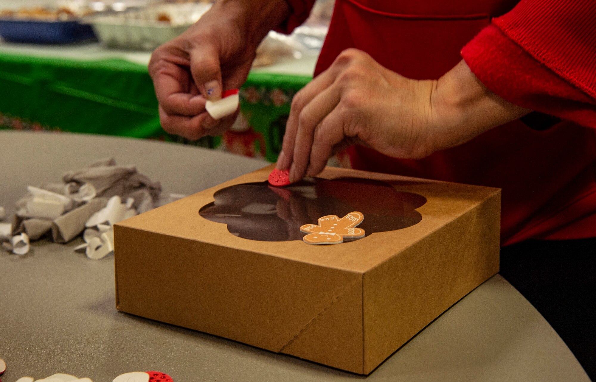 Cynthia Almogela, Cedar Crest Middle School Christmas coordinator, decorates boxes of donated cookies during Operation Cookie Drop Dec. 9, 2020, at Joint Base Lewis-McChord, Wash. Operation Cookie Drop provides a dozen cookies to Team McChord dorm resident Airmen to provide them some holiday cheer during the winter season. (U.S. Air Force photo by Senior Airman Tryphena Mayhugh)