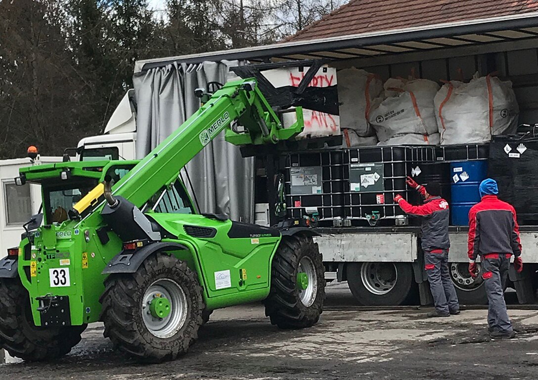 Men load bags onto a truck.