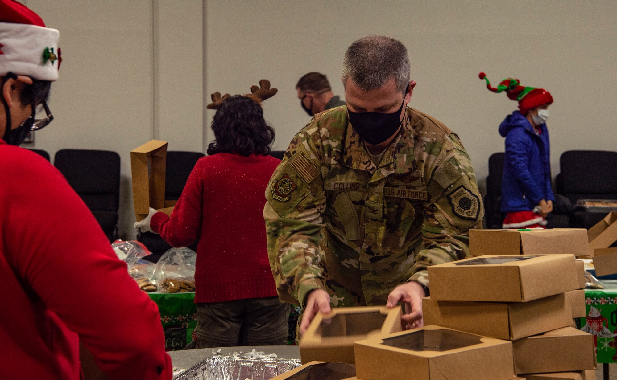 Col. Brian Collins, 62nd Airlift Wing vice commander, assembles boxes together during Operation Cookie Drop Dec. 9, 2020, at Joint Base Lewis-McChord (JBLM), Wash. Leaders, spouses and other volunteers from across JBLM and the community donated cookies and their time to provide a dozen cookies to every dorm resident Airman for the holidays. (U.S. Air Force photo by Senior Airman Tryphena Mayhugh)