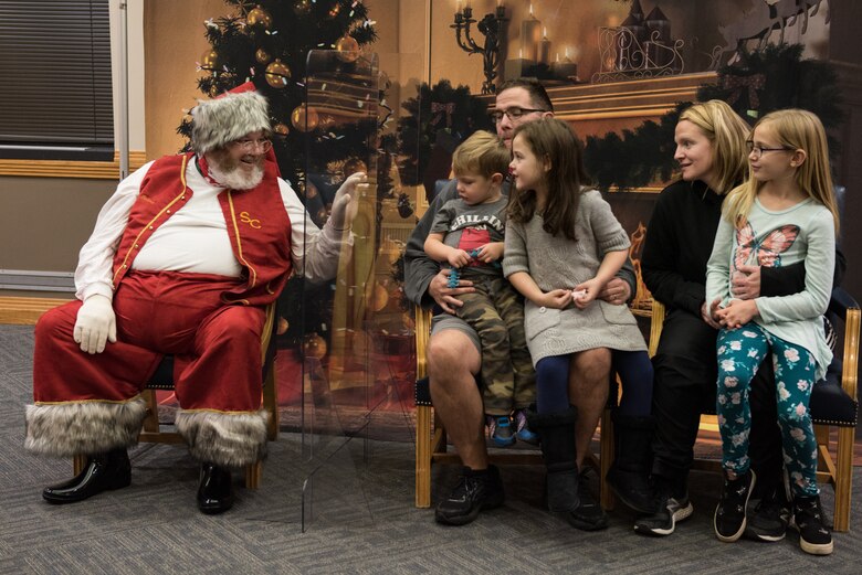 The Lawter family met with Santa Claus at the annual Christmas Tree Lighting Ceremony at Whiteman Air Force Base, Missouri, Dec. 8, 2020. Attendees met with Santa by sitting apart from him and safely distancing from others to prevent the spread of COVID-19. (U.S. Air Force photo by Airman 1st Class Christina Carter)