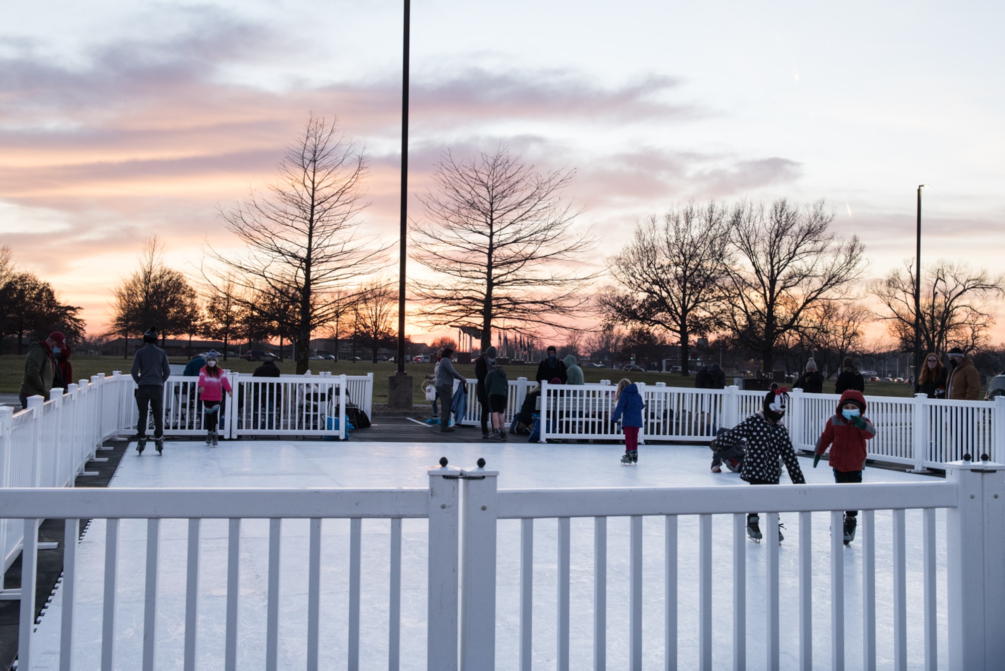 Airman and family members ice skate at the annual Christmas Tree Lighting Ceremony at Whiteman Air Force Base, Missouri, Dec. 8, 2020. The ice skating rink allowed kids of all ages to come together safely and have fun while wearing masks to prevent the spread of COVID-19.(U.S. Air Force photo by Airman 1st Class Christina Carter)