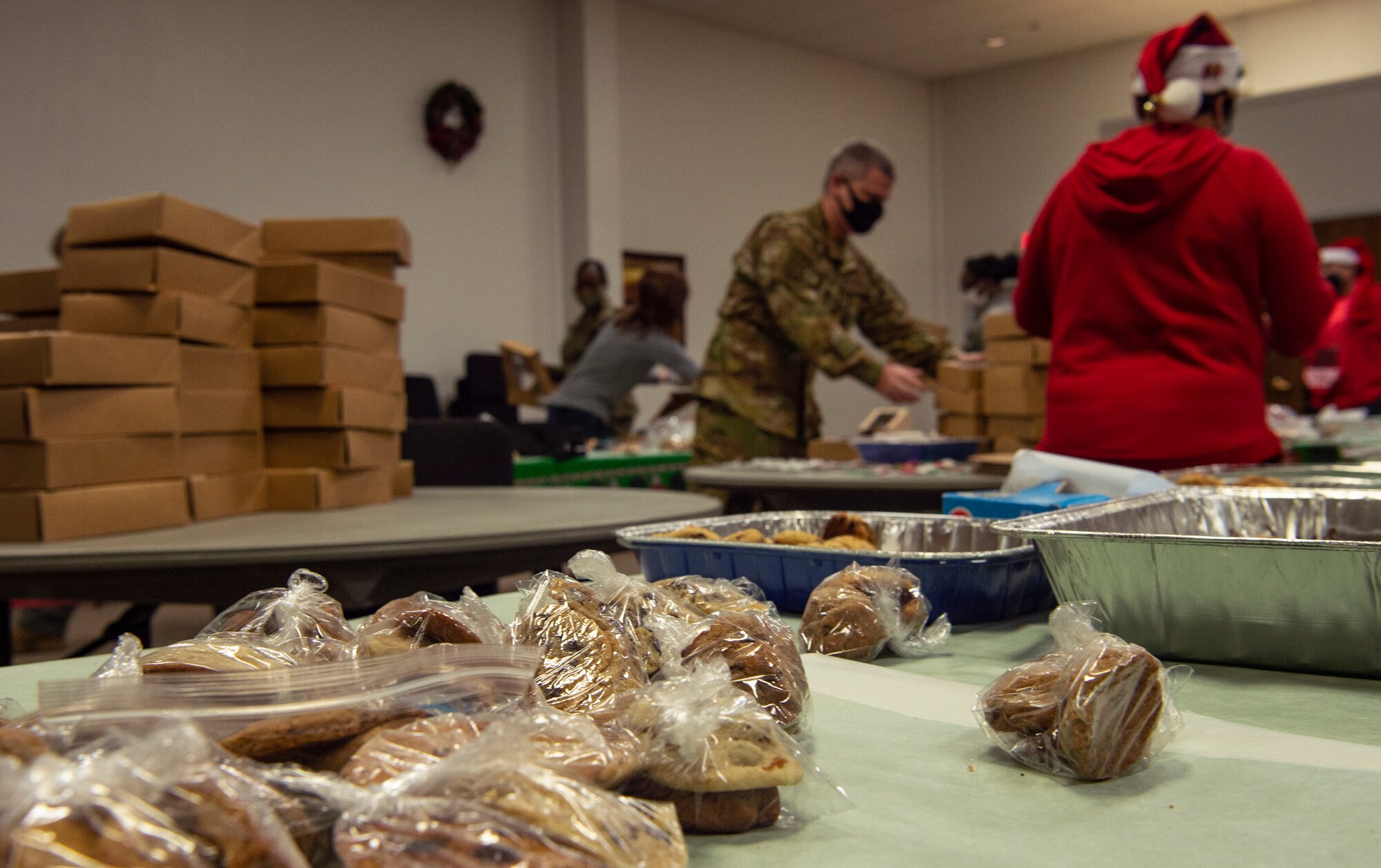 Volunteers box up donated cookies for dorm resident Airmen during Operation Cookie Drop Dec. 9, 2020, at Joint Base Lewis-McChord, Wash. The operation received more than 1,000 dozen cookies for the dorm Airmen. (U.S. Air Force photo by Senior Airman Tryphena Mayhugh)