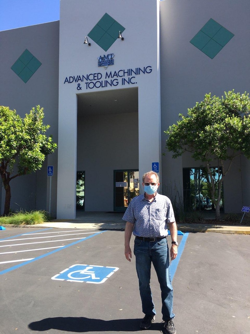 A man stands in front of a building