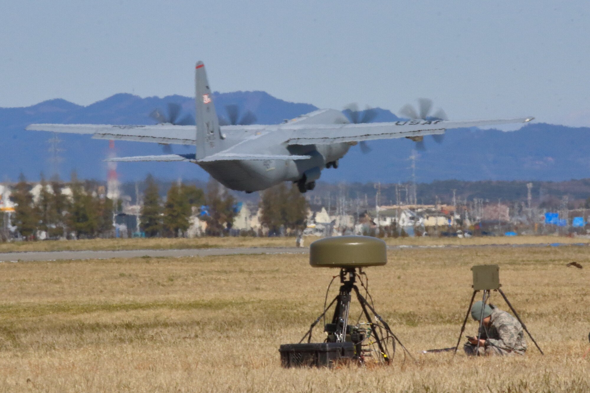 Senior Airman Steven Zhao, 374th Operations Support Squadron Radar, Airfield, and Weather Systems journeyman calibrates the TRN-41 mobile Tactical Air Navigation system during Agile Combat Employment training at Yokota Air Base, Japan, April 13, 2020. RAWS personnel trained Airmen from air traffic control and airfield management to set-up, calibrate and run of the system, in the field. (Courtesy photo by Capt. Arie Church)
