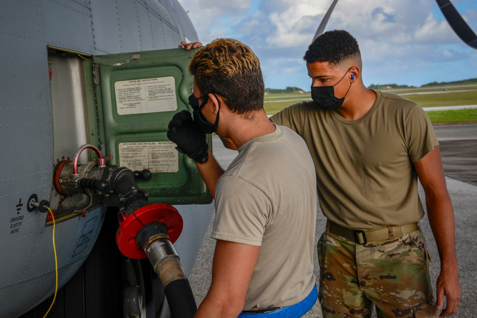 Senior Airman Stephen Yarbrough (left), 374th Aircraft Maintenance Squadron crew chief out of Yokota Air Base, Japan, and Airman 1st Class Andre Anderson, 36th Logistics Readiness Squadron fuel distribution operator, attaches a fuel hose to C-130J Super Hercules during Operation Christmas Drop 2020 at Andersen Air Force Base, Guam, Dec. 9.