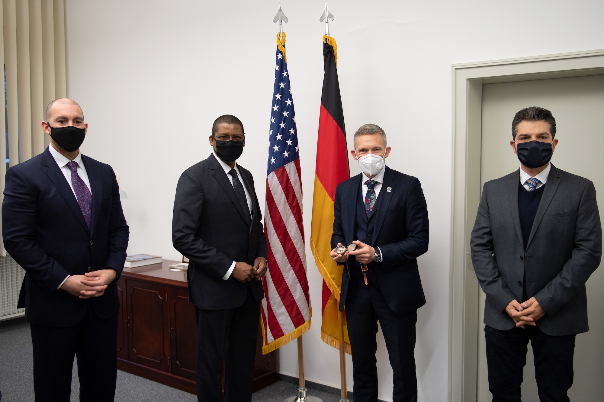 Four men standing around the American and German flags.