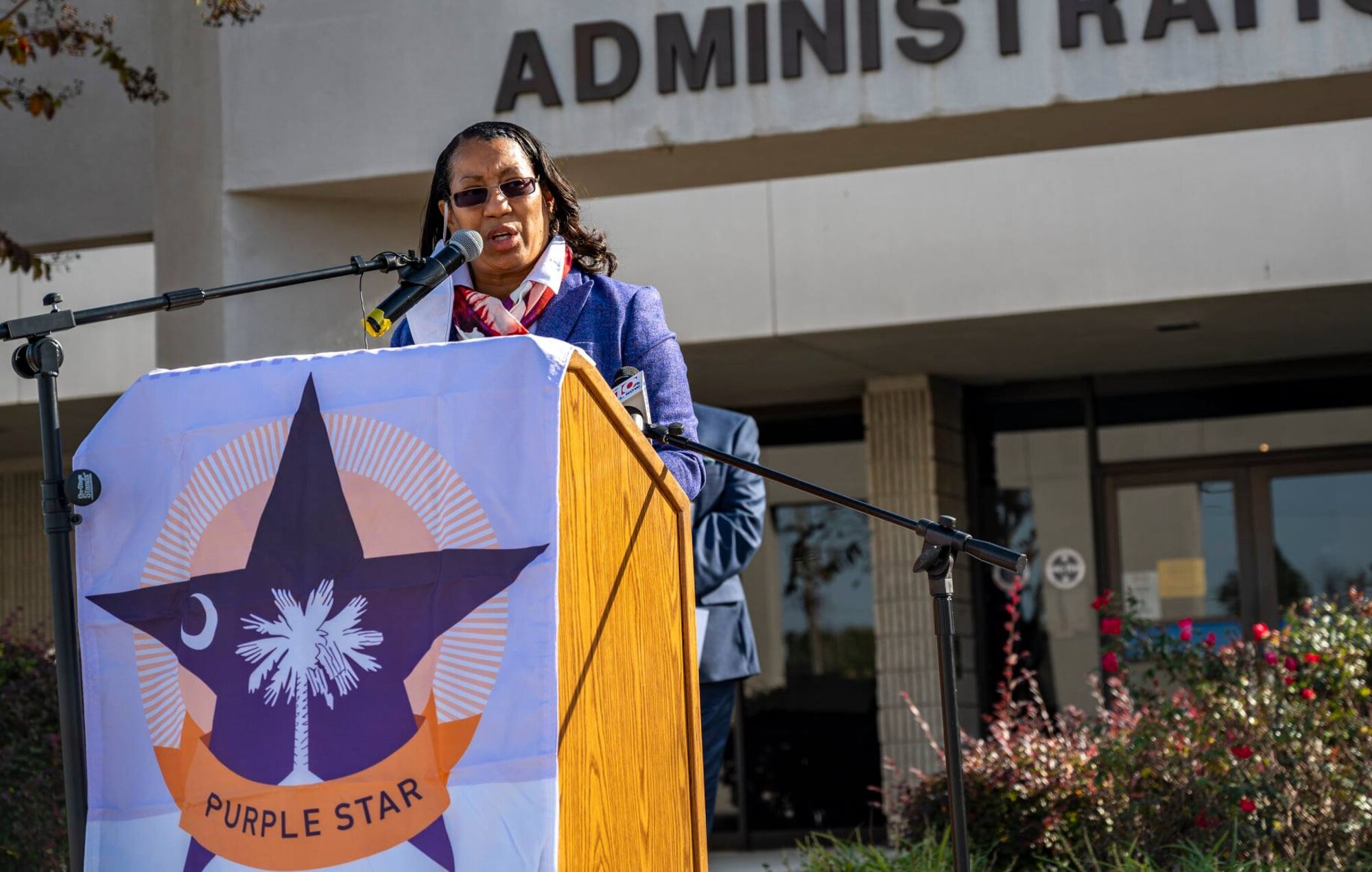 A photo of someone speaking at a podium.