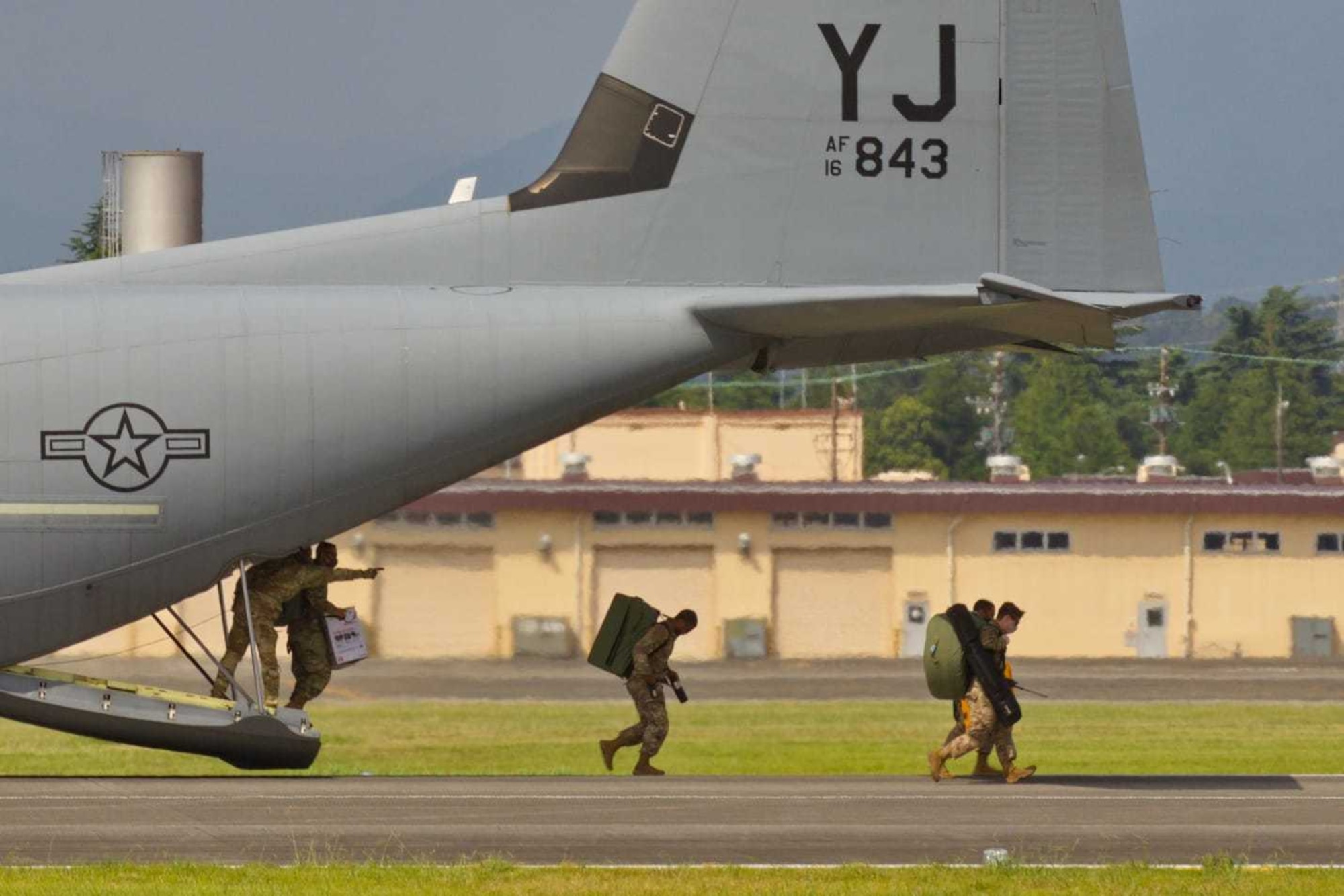 A small team of multi-capable Airmen from the 374th Operations Support Squadron airfield operations flight disembark a C-130J on the runway at Yokota Air Base, Japan, during an Agile Combat Employment proof-of-concept demo, Aug. 19, 2020. Airmen from across the OSS set-up, flyability checked, and operationalized a refurbished mobile Tactical Air Navigation system for use in under an hour. (Courtesy photo by Capt. Arie Church)