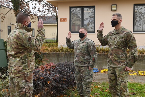 U.S. Air Force Lt. Col. Brian Robertson, 606th Air Control Squadron commander, administers the oath of enlistment to Senior Master Sgt. Sean Winters, 606th ACS cyber operations and maintenance superintendent, and Senior Master Sgt. Paul Norris, 606th ACS cyber operations and maintenance operations superintendent, as they transfer into the U.S. Space Force at Aviano Air Base Italy, Dec. 3, 2020. After Air Force Space Command was redesignated as the U.S. Space Force in December of 2019, the Department of Defense began consolidating several space missions, units, and career fields into this new branch.