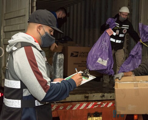U.S. Air Force Airmen assigned to the 386th Expeditionary Force Support Squadron mail control activity unit pose for a photo at Kuwait International Airport’s Joint Military Mail Terminal, Dec. 4, 2020.
