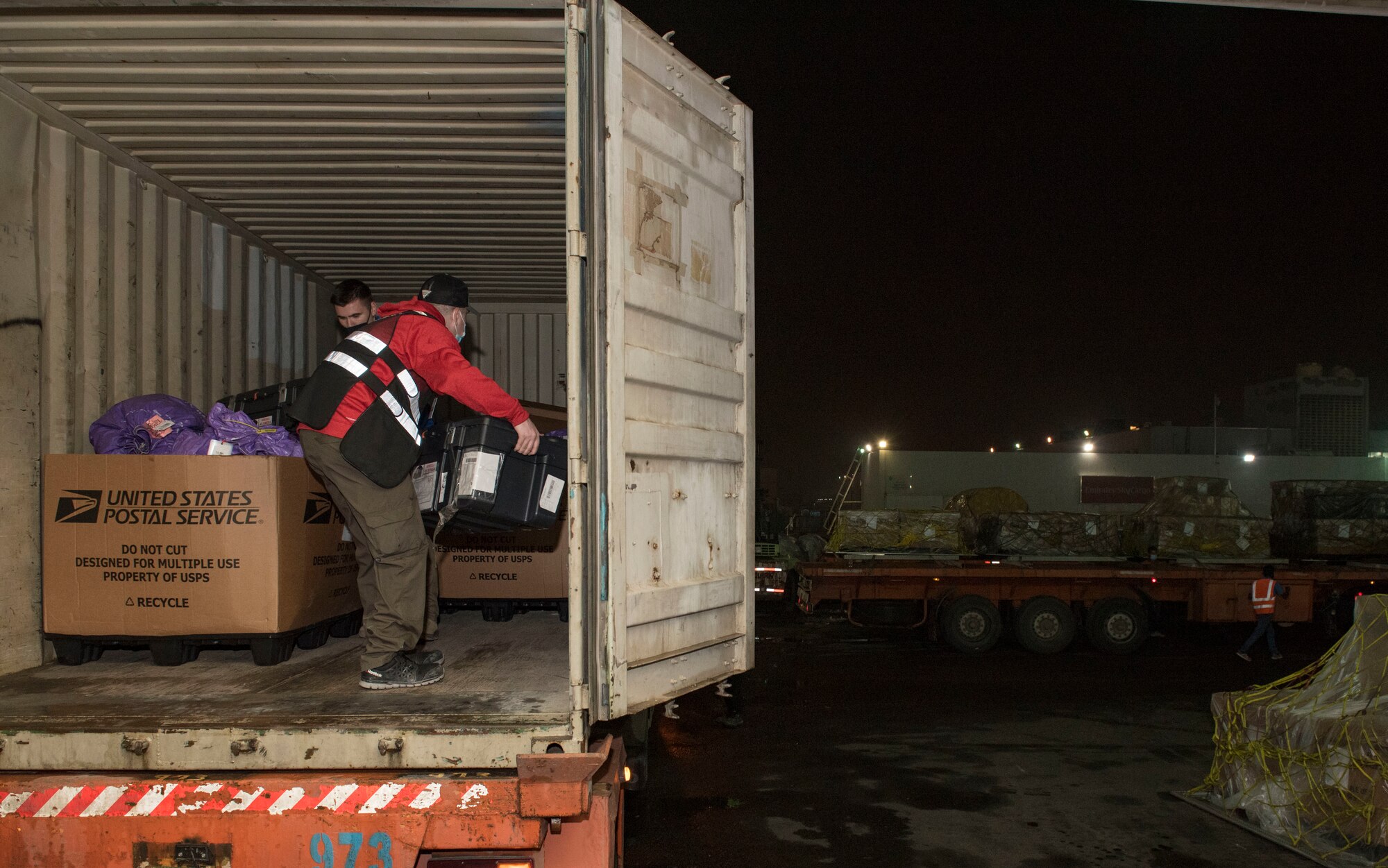 U.S. Air Force Staff Sgt. Ryan Robinson, 386th Expeditionary Force Support Squadron mail control activity operations supervisor, and Staff Sgt. Matthew Deschaine, 386th EFSS MCA certifier supervisor, unload mail at Kuwait International Airport’s Joint Military Mail Terminal, Dec. 4, 2020.