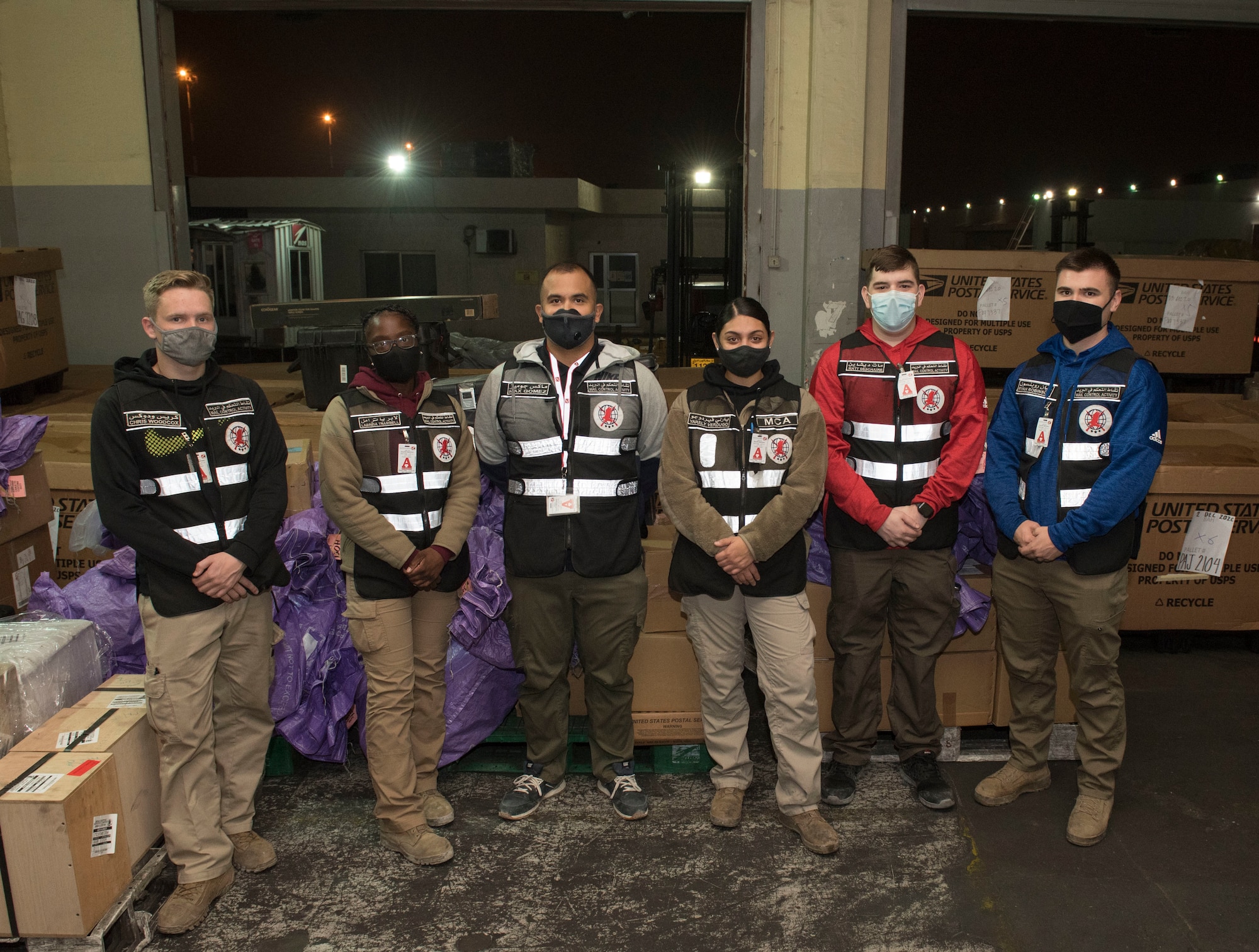 U.S. Air Force Airmen assigned to the 386th Expeditionary Force Support Squadron mail control activity unit pose for a photo at Kuwait International Airport’s Joint Military Mail Terminal, Dec. 4, 2020.