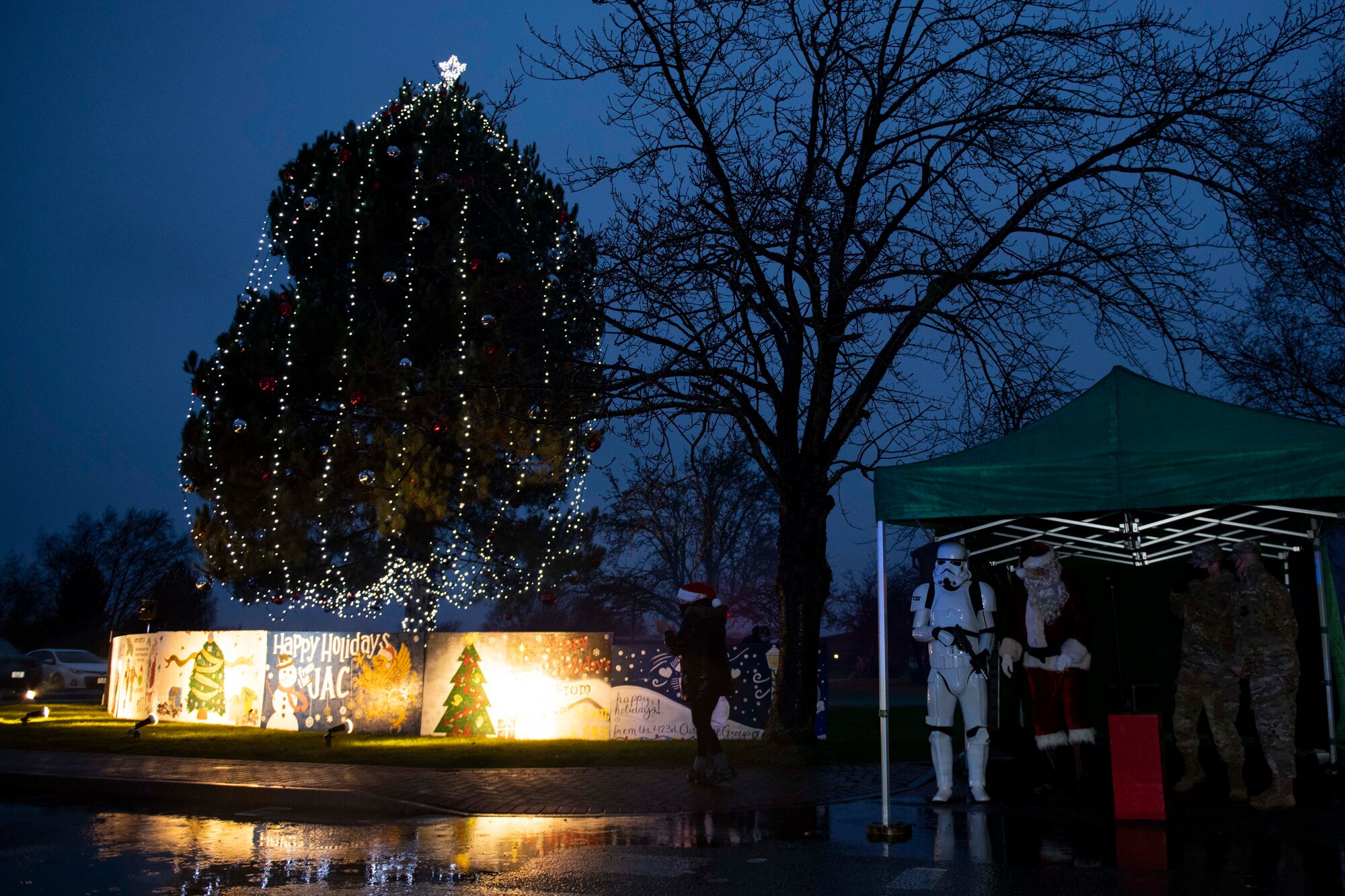 Members of the 501st Combat Support Wing community gather for a tree lighting ceremony at RAF Alconbury, England, Dec. 4, 2020. Col. Kurt Wendt, 501 CSW commander, and Chief Master Sgt. Daniel Keene, 501 CSW command chief, lit the tree with Santa Clause. (U.S. Air Force photo by Senior Airman Jennifer Zima)