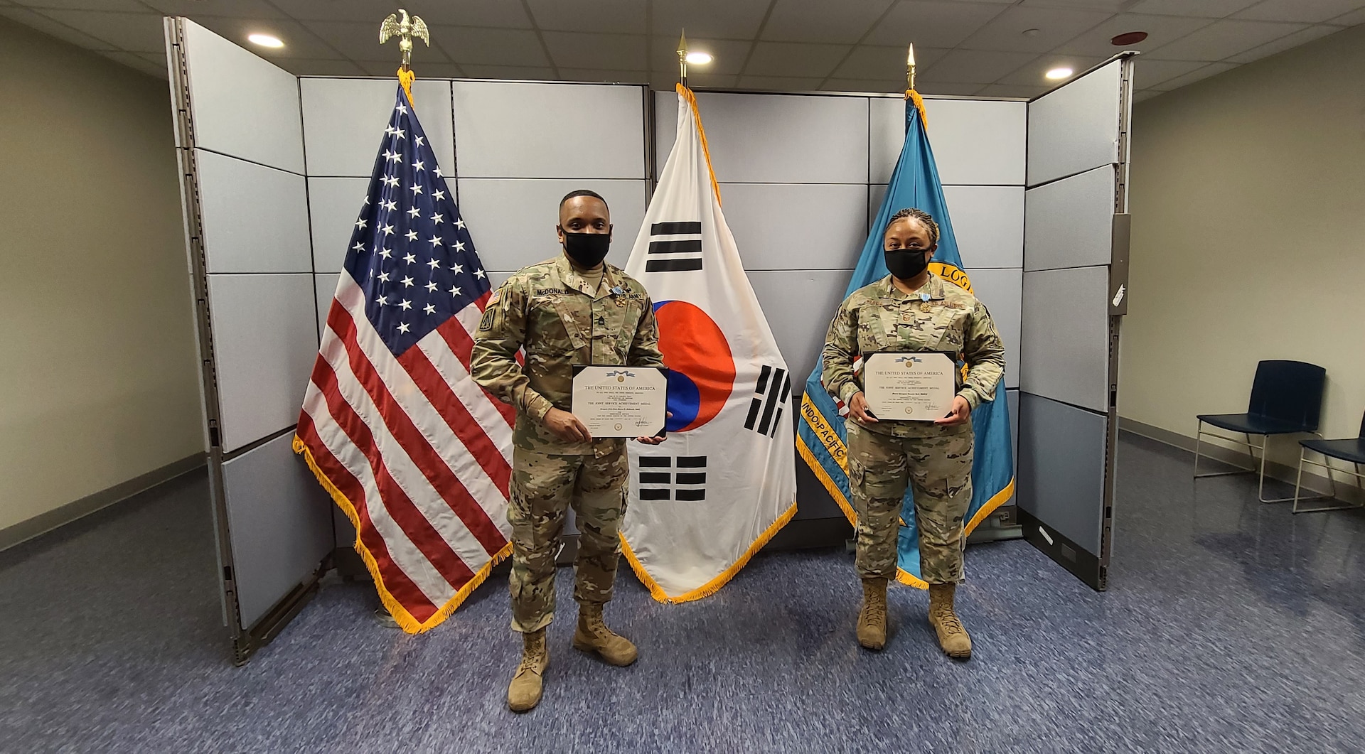 Man and woman hold certificates they received at an awards ceremony held at Camp Humphreys, Korea.