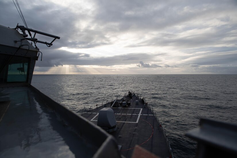 The sun  is seen between clouds from a ship in the Atlantic Ocean.