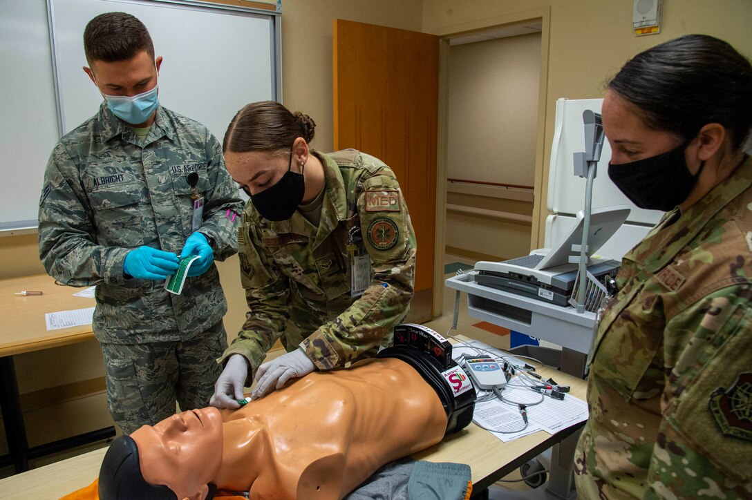 Airmen practice nursing skills on a mannequin.