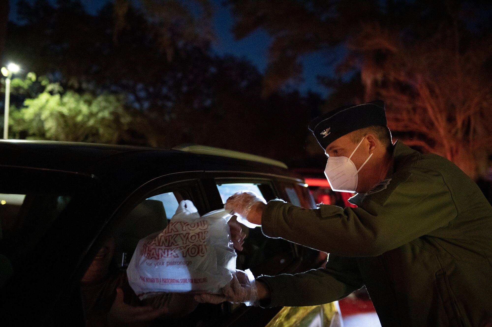 A photo of Col. Dan Walls serving meals to a family during a drive-through holiday dinner.