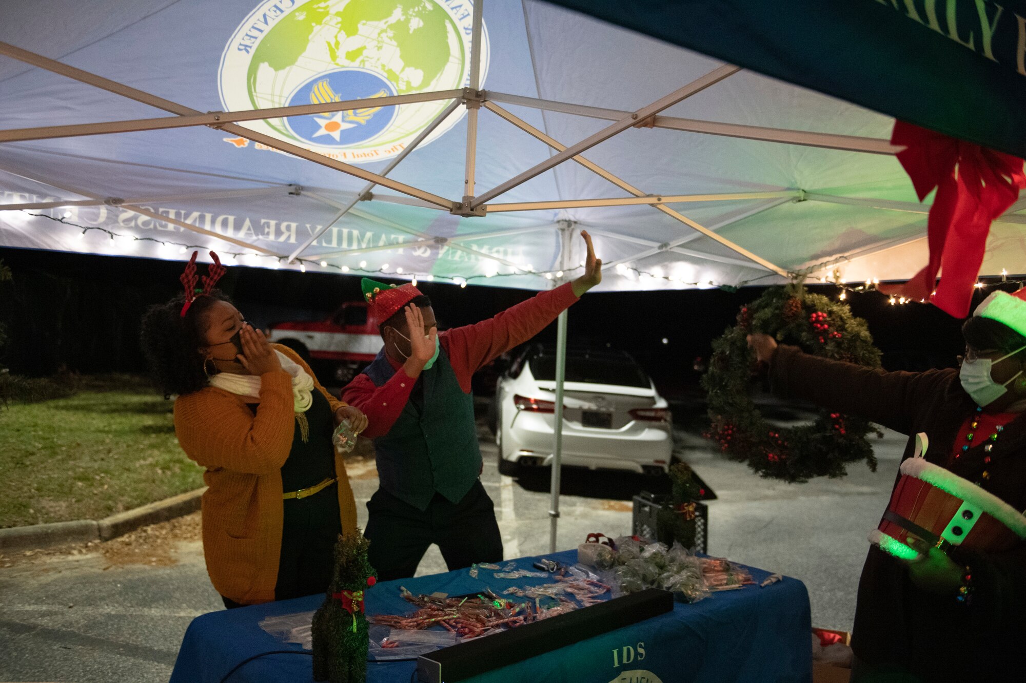 A photo of volunteers dancing to holiday music during a drive-through holiday dinner.