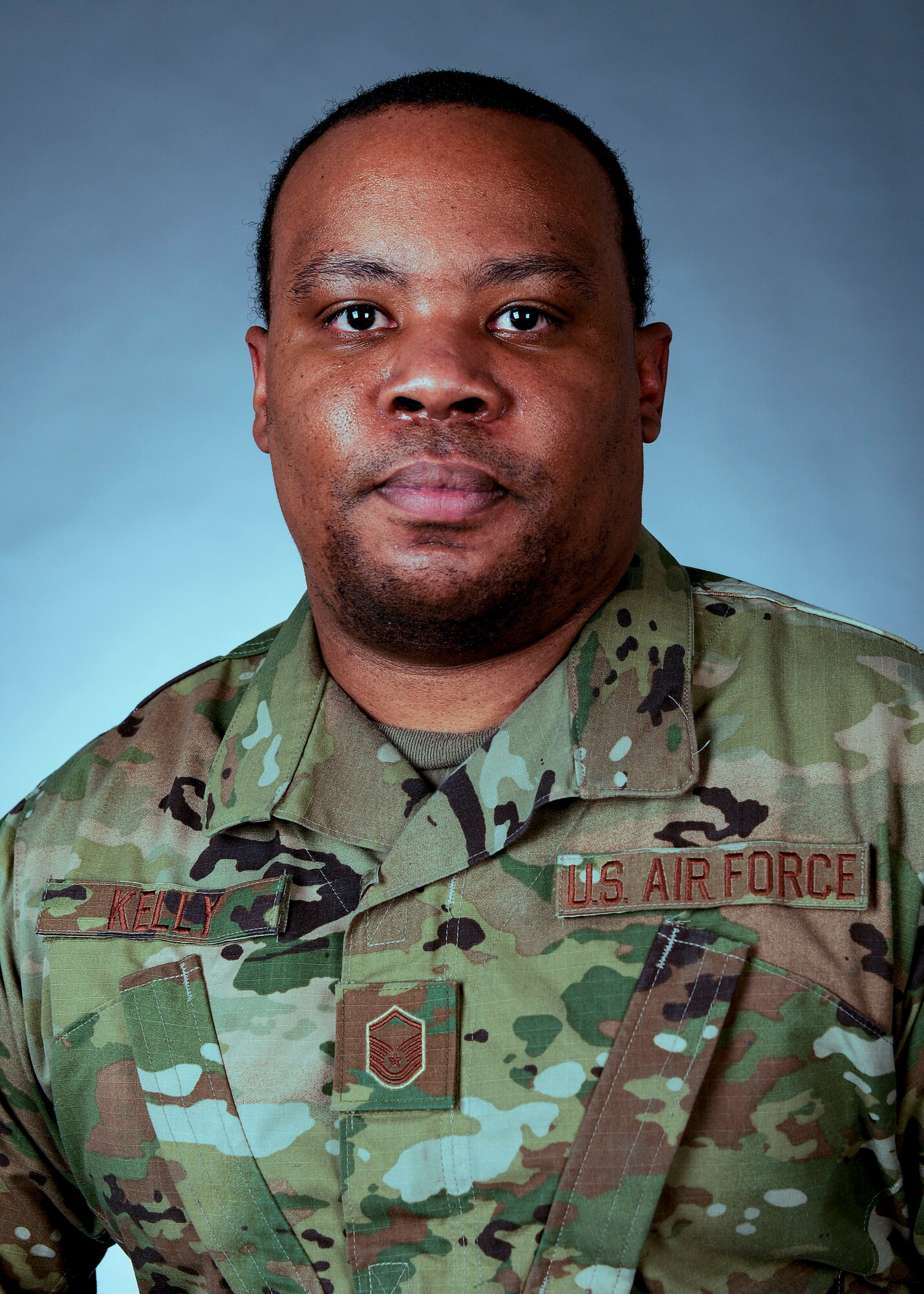 A close-up photograph of a male Airman looking at the camera.