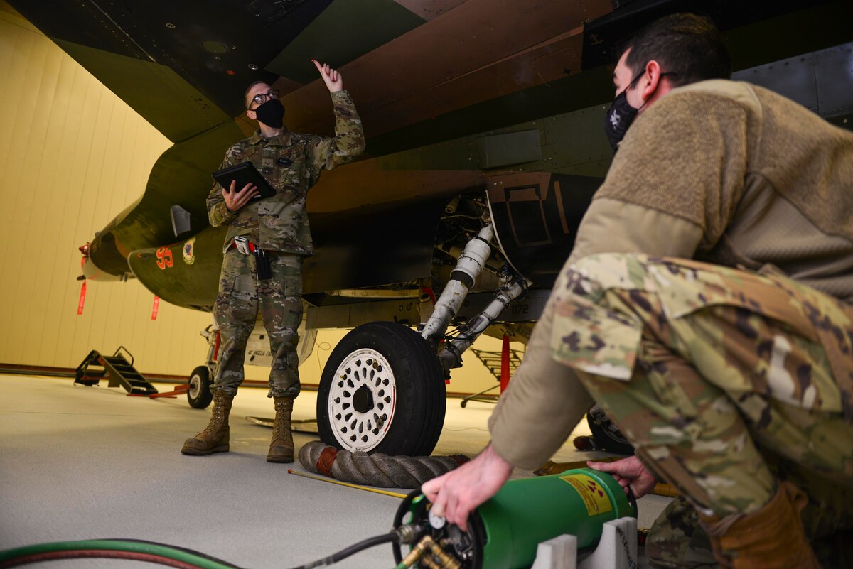 U.S. Air Force Senior Airman Timothy Carlson, a 354th Maintenance Squadron non-destructive inspection (NDI) journeyman, guides Staff Sgt. Zachary Chambers, a 354th MXS NDI craftsman, as he aligns an x-ray tubehead on Eielson Air Force Base, Alaska, Dec. 9, 2020