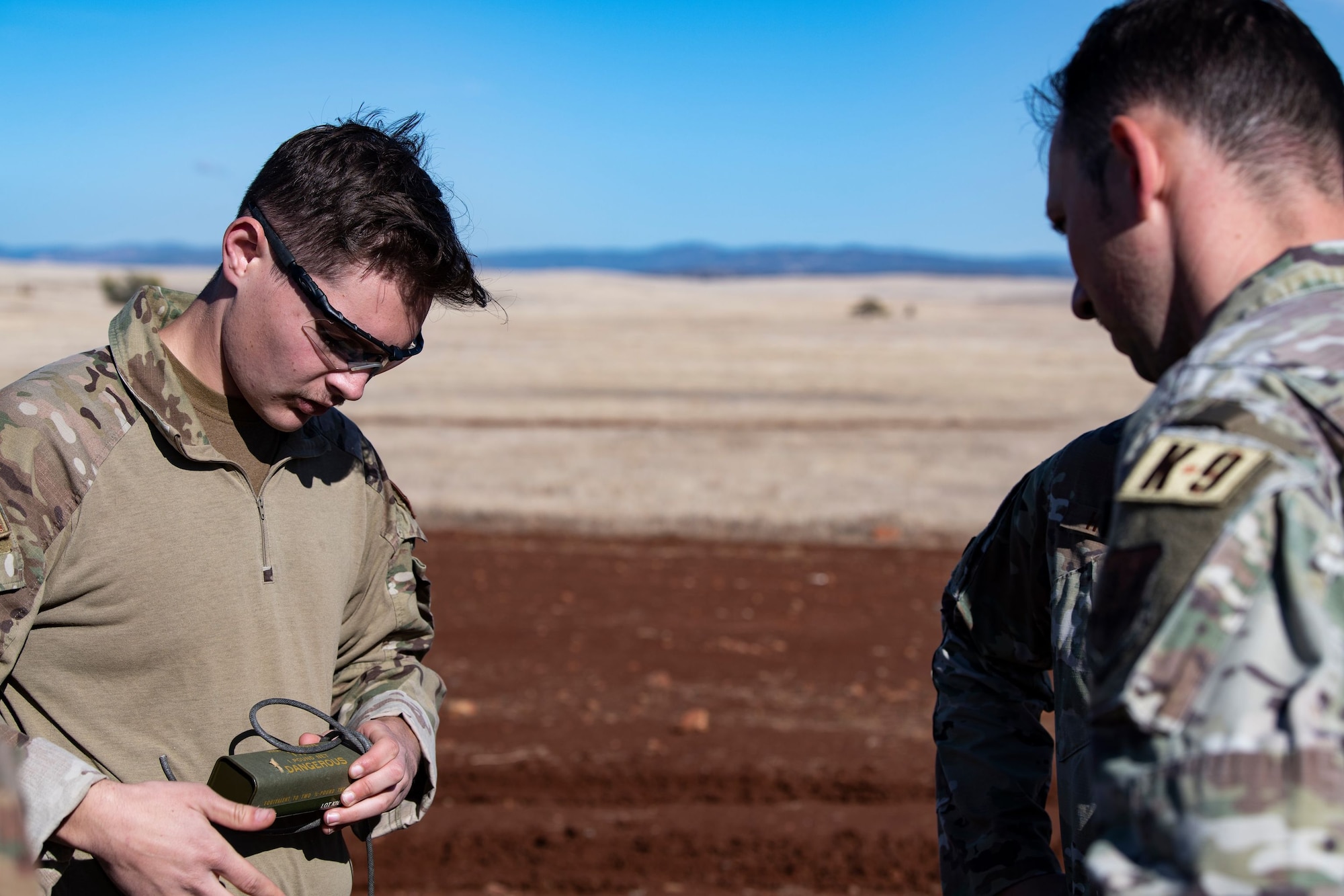 Senior Airman Hunter Rudnik, 9th Civil Engineering Squadron Explosive Ordnance Disposal team member, demonstrates how to wrap detonating cord for Staff Sgt. David Baumgartner, 9th Security Forces Squadron (SFS) K-9 handler, during military working dog detection training on Beale Air Force Base.