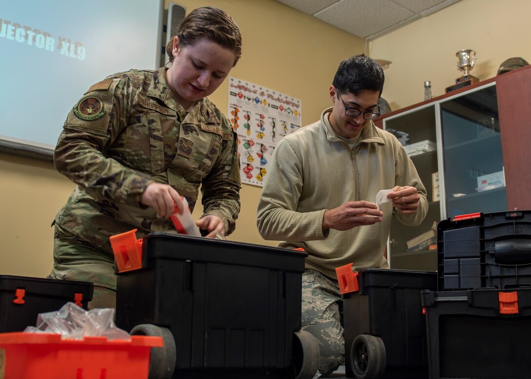 Airman 1st Class Delaney Thompson (left) and Airman 1st Class Abimanuel Valle Ramos (right), 4th Civil Engineer Squadron emergency managers, fill a bag with items needed to conduct sample training at Seymour Johnson Air Force Base, North Carolina, Nov. 19, 2020.