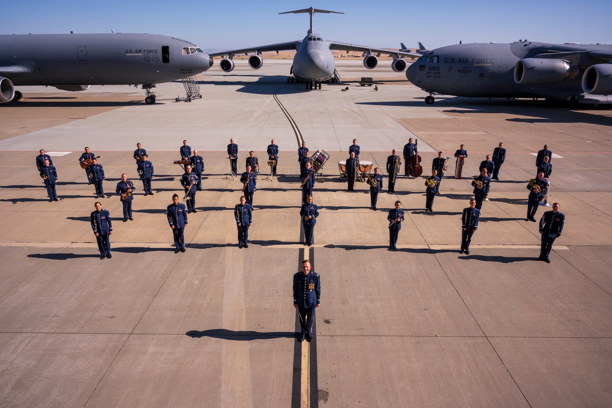 Members of the U.S. Air Force Band of the Golden West pose on the flight line with each of the three airframes stationed at Travis Air Force Base, California, behind them. Band members recently released “American Tapestry,” an album of songs celebrating the many differences between Americans and their experiences. (Courtesy Photo)