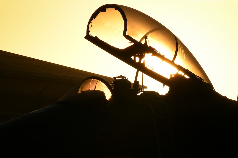 A pilot sits in an open cockpit.